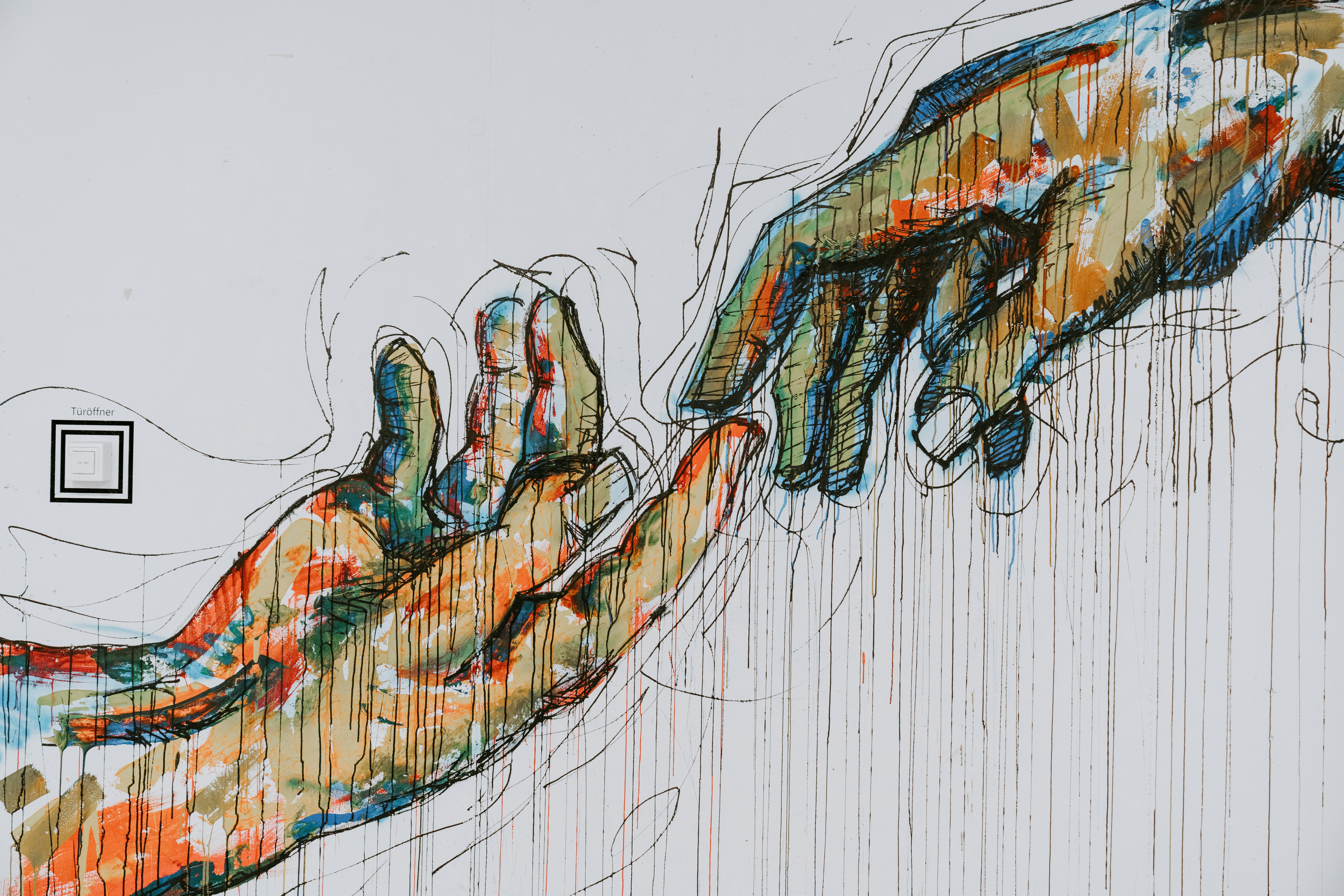 An art work of two hands connecting through a finger.