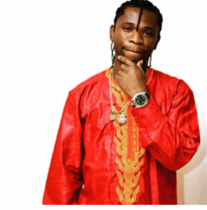 Speed wearing a native attire with his hands on his chin