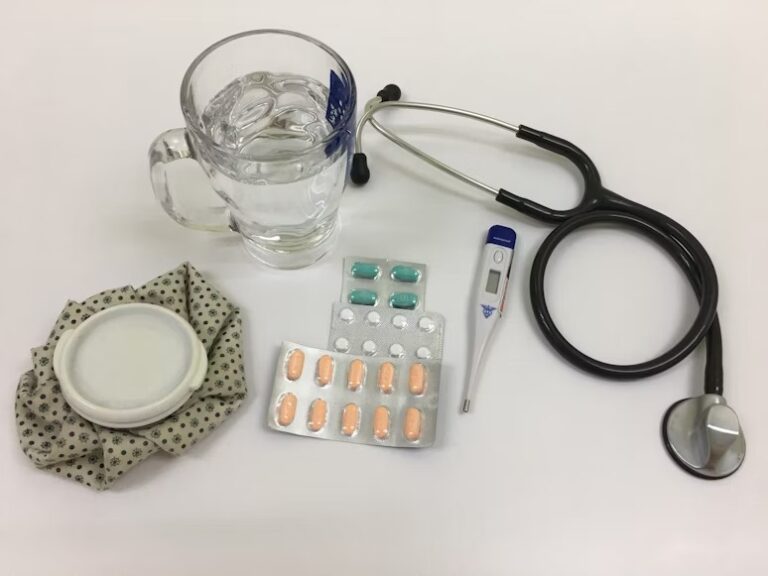 Glass of water with medicines, thermometer, stethoscope and icebag. Photo Source: Kristine Wook via Unsplash.