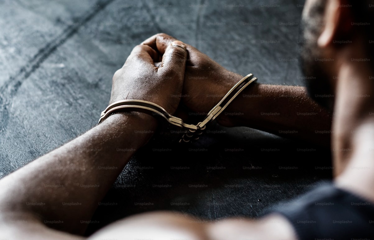 Handcuffed hands. Photo credit: Curated lifestyle on Unsplash