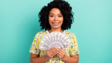 GENDERED MONEY: How Money Works Less for Women than Men 2 A black woman holding money. Photo credit: Deagreez on unsplash