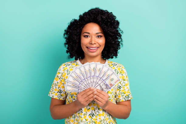 A black woman holding money. Photo credit: Deagreez on unsplash