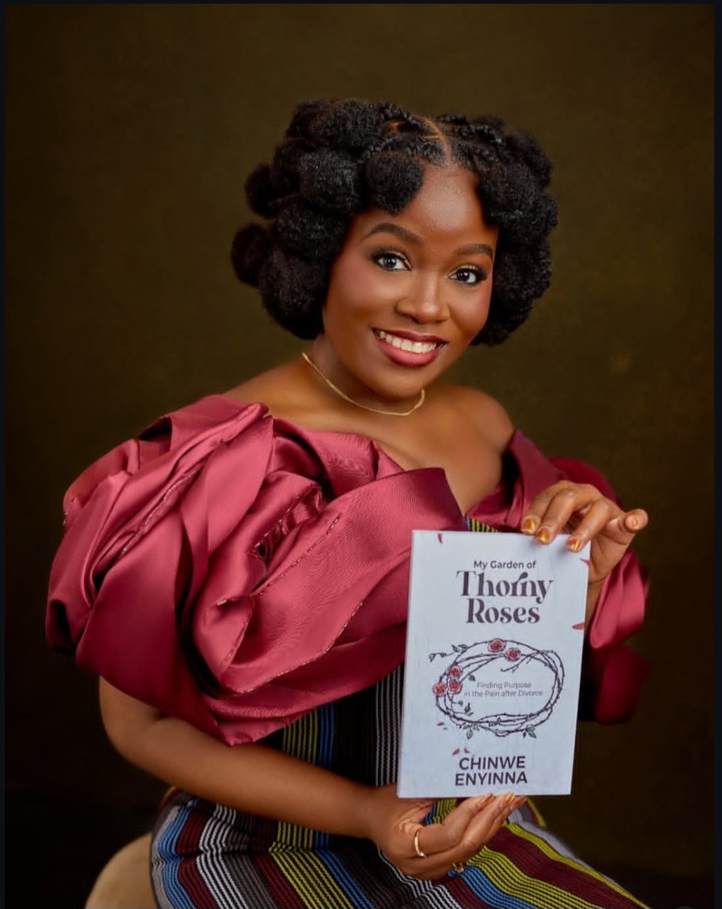 Chinwe Enyinna with her debut novel, My Garden of Thorny Roses  Photo credit: Chinwe's IG